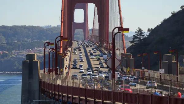 The Golden Gate bridge viewed from Marin, with cars passing in either direction on a sunny day.