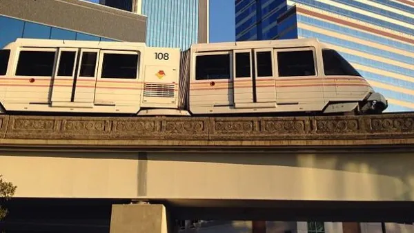 Jacksonville Skyway monorail train passing on elevated rail in front of downtown buildings