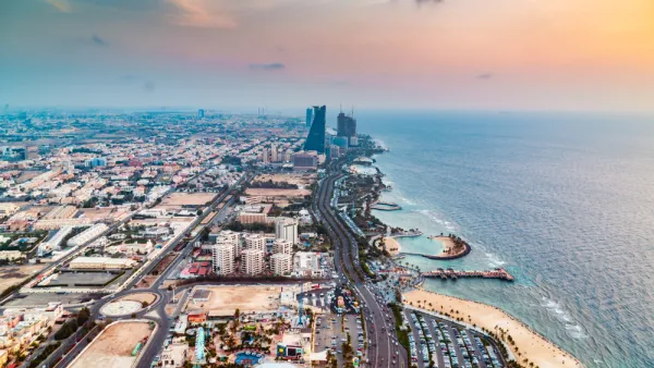 An aerial view down the length of the Jeddah coastline in Saudi Arabia, showing coastal developments, beaches, and a few high-rise buildings along the shoreline.