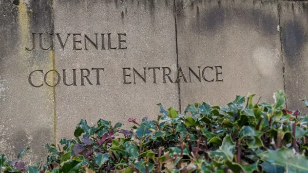 Weathered stone slabs with the words Juvenile Court Entrance engraved into it.