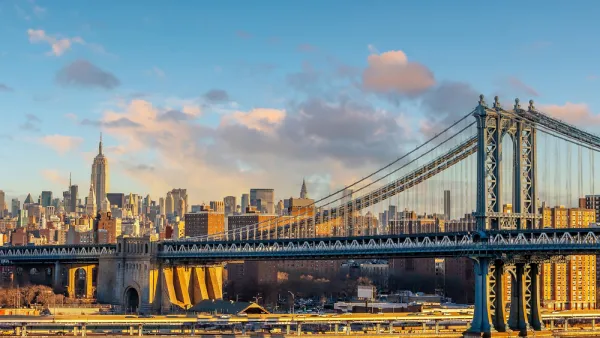 A view of the Manhattan Bridge with the Empire State Building in the distance.