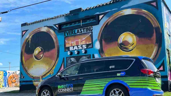 Black and green MetroConnect microtransit van in front of mural of boom box on Miami building.