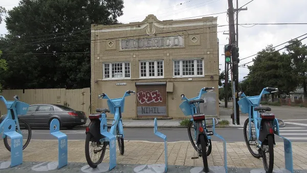 Row of blue Blue Bikes bike share bikes at docked station on sidewalk in New Orleans, Louisiana.