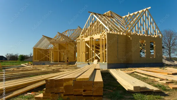 A new house is under construction with the walls and the roof installed but only the frames and trusses, respectively.