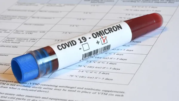 A vial of blood marked "Omicron" sits on top of paperwork indicating relevance to Covid-19.