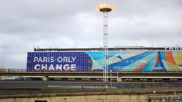 The exterior of a terminal at Orly Airport in France, with a large graphic that reads “Orly Change.”