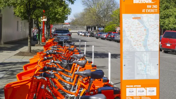 Numerous orange Portland Biketown bikes are parked at a facility in Northwest Oregon.