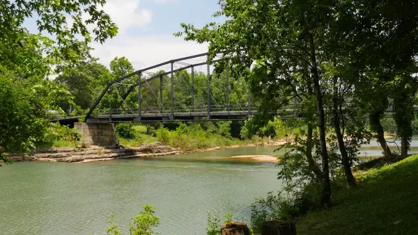 Old wooden bridge with steel railings at the War Eagle River in Rogers, Arkansas.