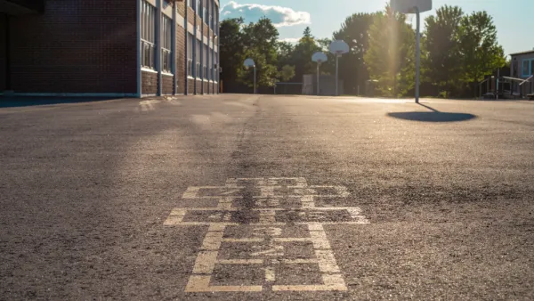 Hopscotch squares on concrete schoolyard with basketball hoop in background
