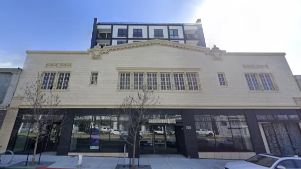 Former auto showroom converted to apartments in Oakland, California with vintage facade and new tower rising above