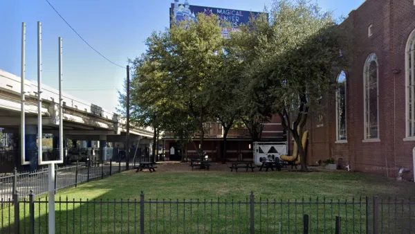 Google street view of grassy lot next to brick church with elevated freeway on other side in Houston, Texas.