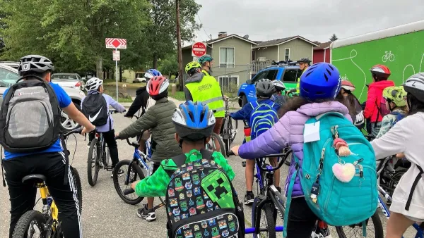 Group of children with backpacks and bike helmets going to school.