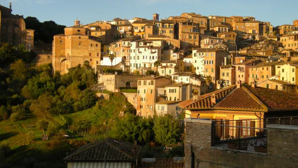 The city of Siena in Italy, located on a hillside and bathed in Tuscan sunlight.
