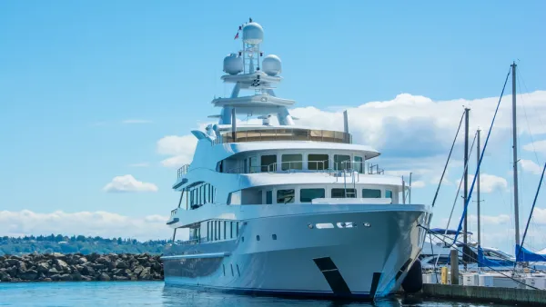A very large yacht at berth in Washington, with wooded hills in the background.