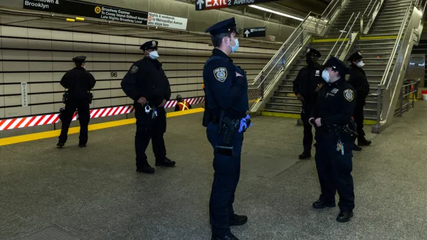 A group of police officers wearing masks during the Covid-19 pandemic gather on a subway platform in New York City.