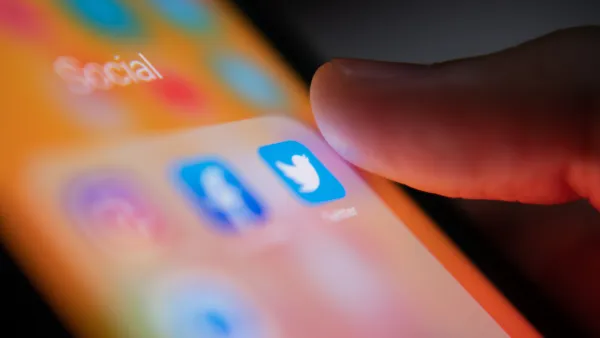 A person’s thumb hovers over the Twitter app on a smart phone.