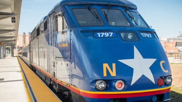 Blue train with white star and NC logo at platform in North Carolina.