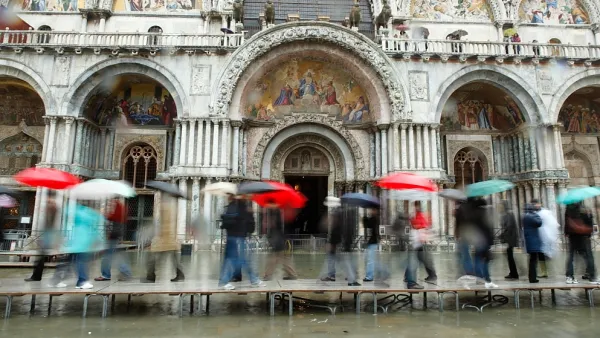Tourists on walkways over flood waters in Venice