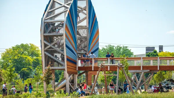 Large wood structure with bridge and people standing on it in green park in Toledo, Ohio.