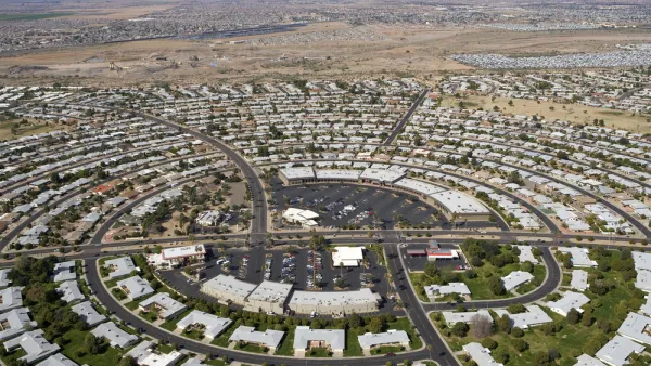 Aerial view of circular street pattern with buildings in Sun City, Arizona with desert mountains in background