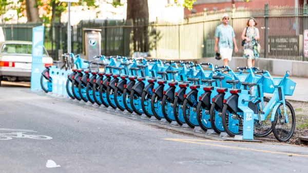 Row of blue New Orleans bike share bikes at a docked station on street