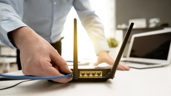 Man plugging cable into home modem