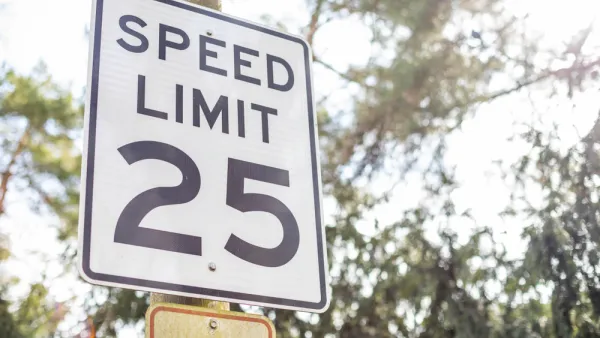 Black and white 25 mph speed limit sign on post with trees in background