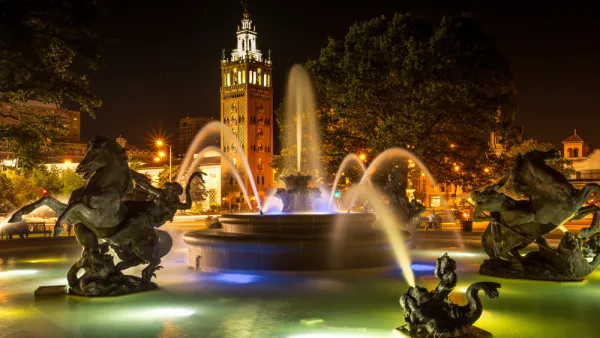 Nighttime shot of decorative fountain with horses and Country Club Plaza tower in background