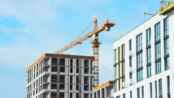 Apartment buildings under construction with crane.