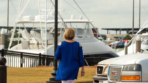 Woman walking at marina in Pensacola, FL with boat in background