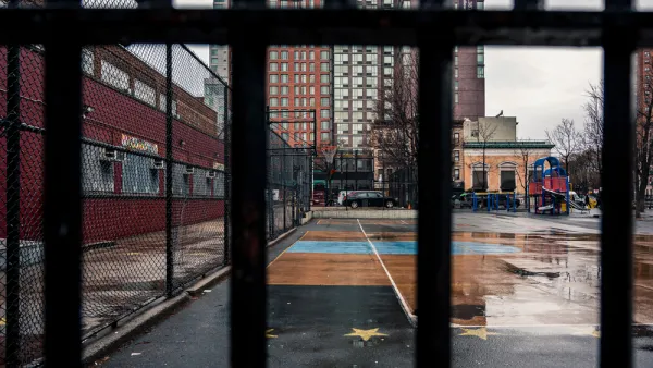 View of concrete schoolyard in New York City through fence