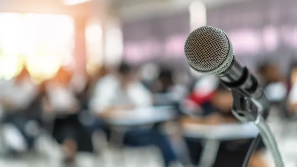 Close-up of microphone on stand with blurred seating in background