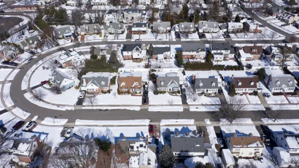 Aerial view of snowy single-family homes in suburban Long Island, New York