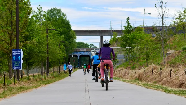 People on bikes ride along paved Atlanta BeltLine bike trail