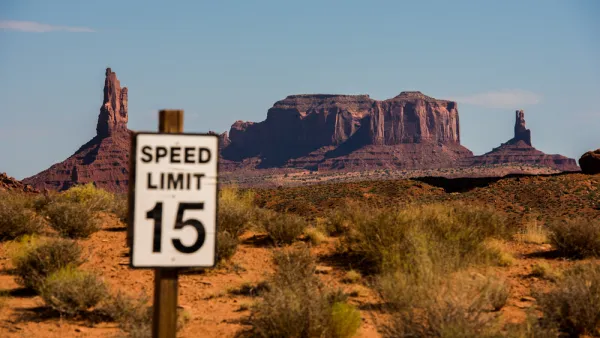 View of 15mph speed limit sign with Monument Valley mesas in the background