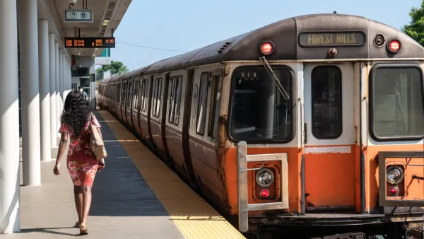 Orange Line train pulling into station with one woman waiting to board in Boston, Massachusetts