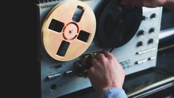 Close-up of reel-to-reel tape recorder with hand turning knob
