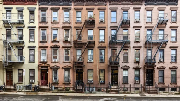Multicolored four-story brick New York City apartment buildings with fire escapes