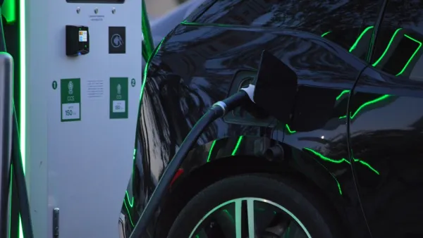 Close-up of black electric car charging at station
