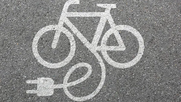 White electric bike logo on asphalt