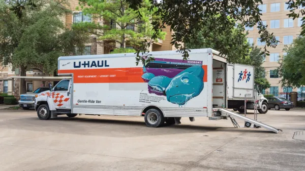 U-Haul moving truck with back door open and loading ramp down on residential street in Houston, Texas