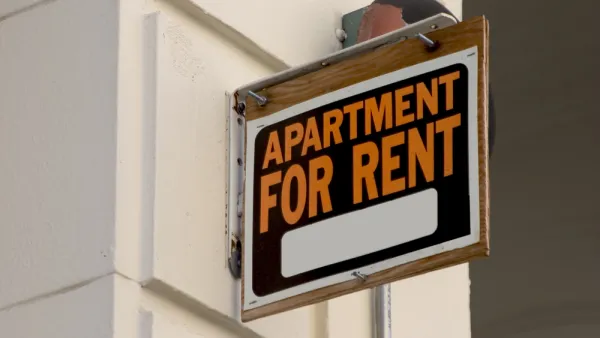 "Apartment for Rent" sign installed perpendicularly on a while building wall
