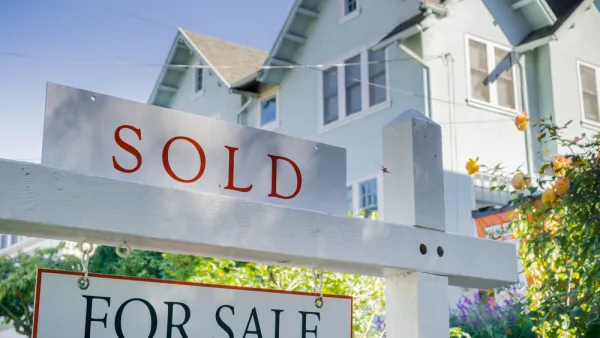 White house with For Sale and SOLD sign