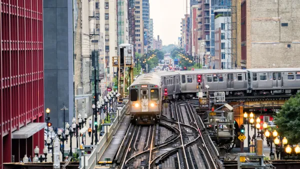 Chicago elevated train over busy city street surrounded by high-rise buildings