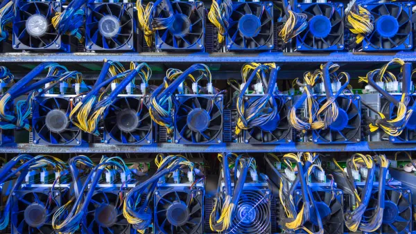 Wall of computer servers with blue and yellow cables for cryptocurrency mining
